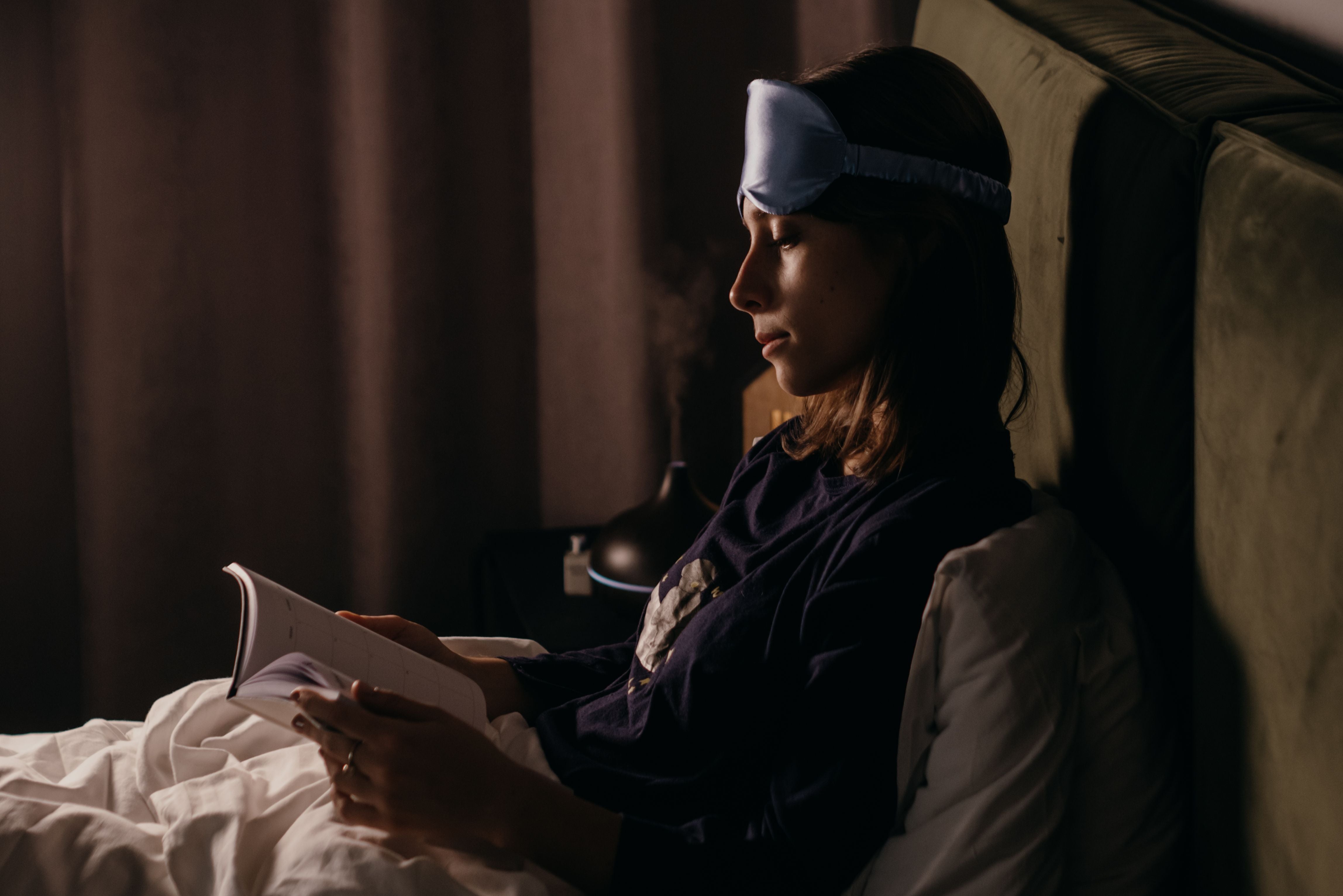 Girl reading booking before going to sleep, maintaining good sleep routine